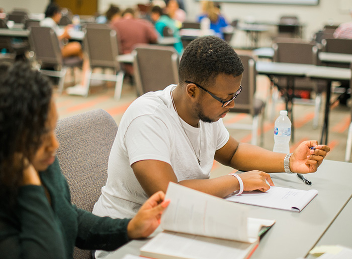 Students looking at a notepad and a book