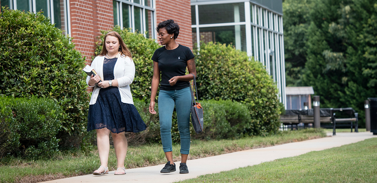 Two students walking on the sidewalk