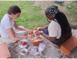two female counseling students sit outside on a picnic blanket