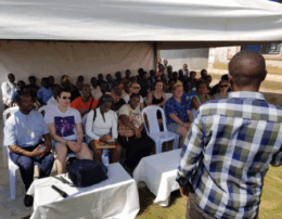 group of people sitting under a tent outside