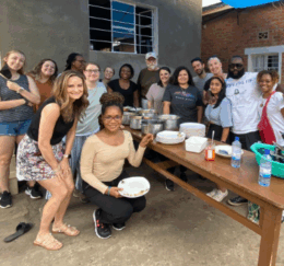 a group of Mercer students stand around a table and smile