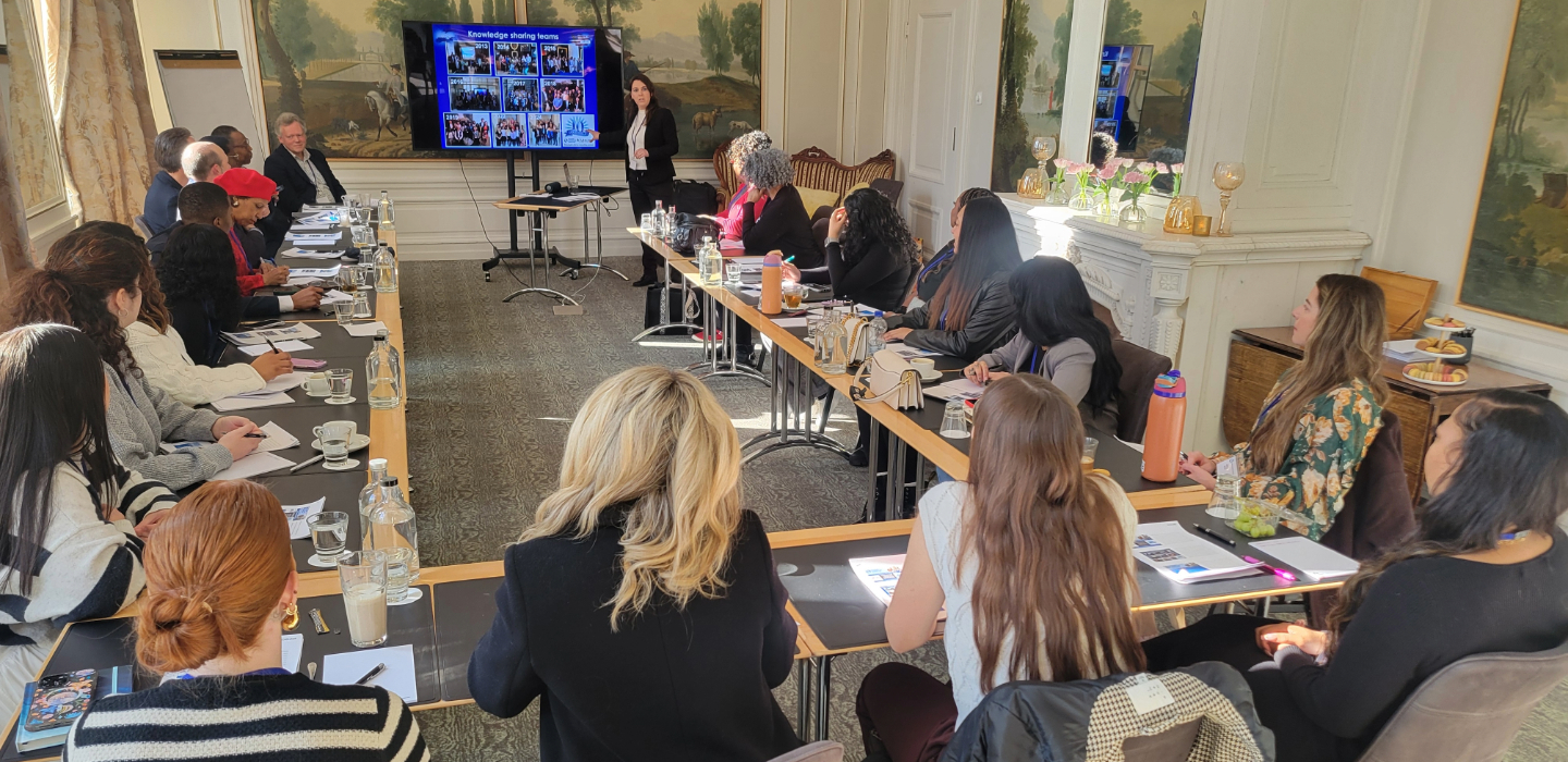 Students sitting around a conference table watching a presenter
